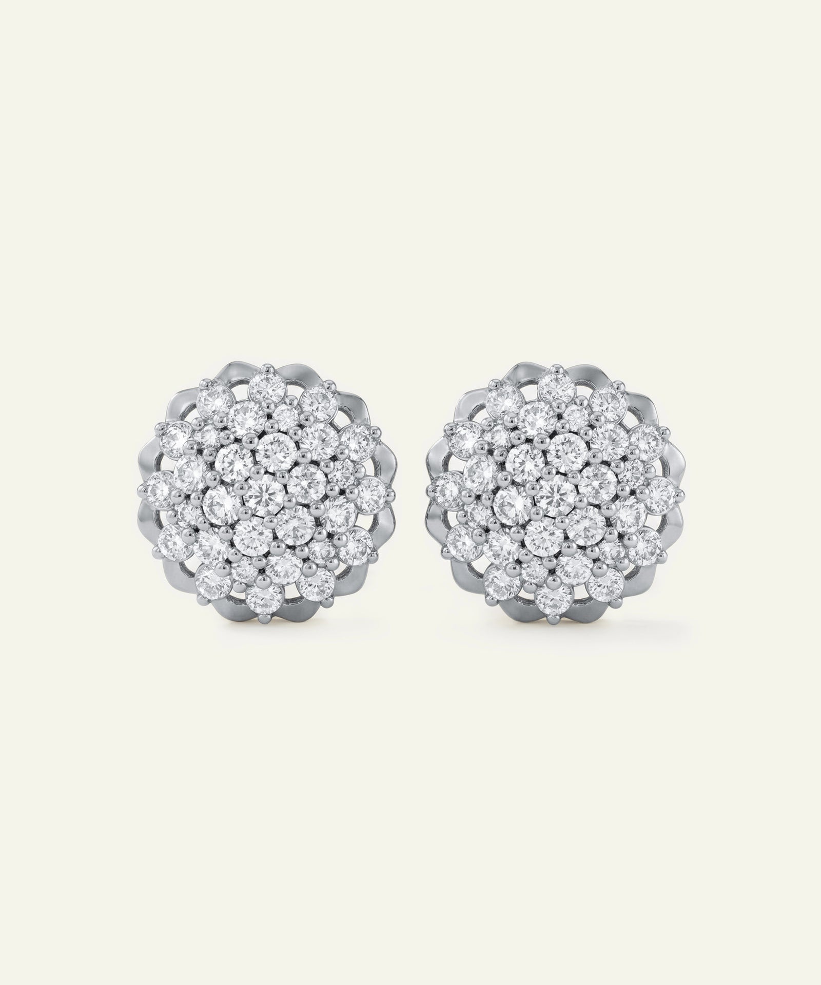 Pair of silver earrings with clear gemstones on a white background