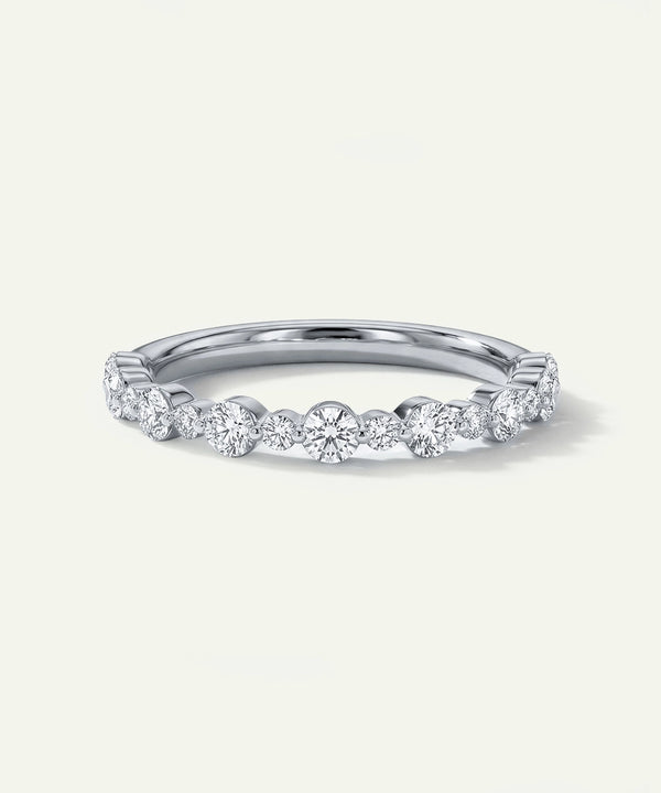 Silver ring with small diamonds on a light gray background