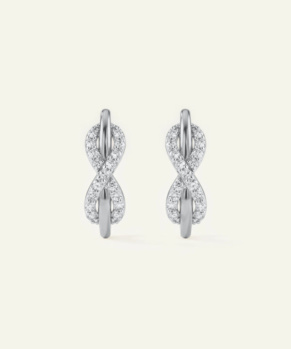 Pair of silver earrings with diamond accents on a white background
