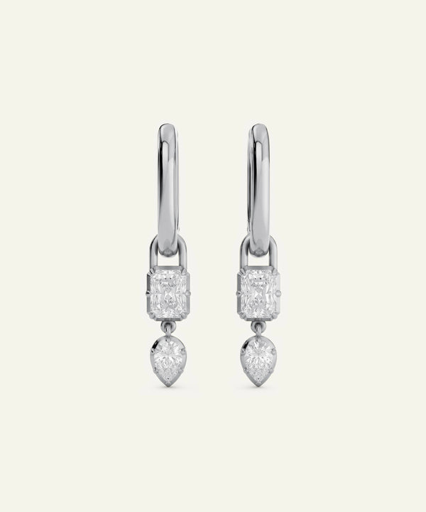 Pair of silver earrings with clear gemstones on a white background