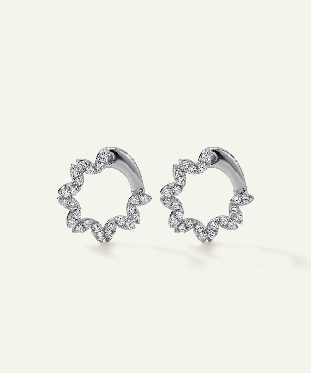 Pair of silver hoop earrings with diamond accents on a light gray background