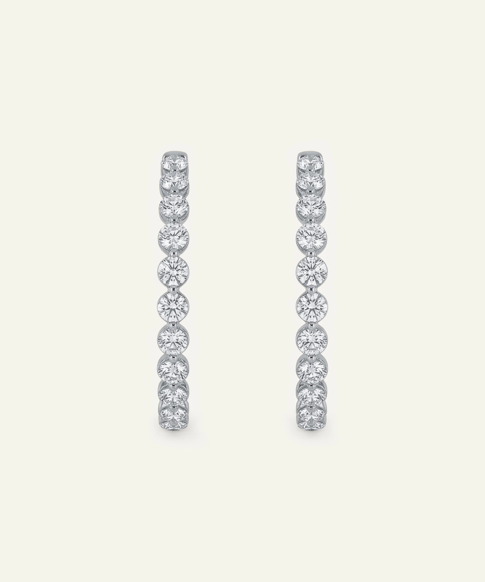 Pair of diamond hoop earrings on a light gray background