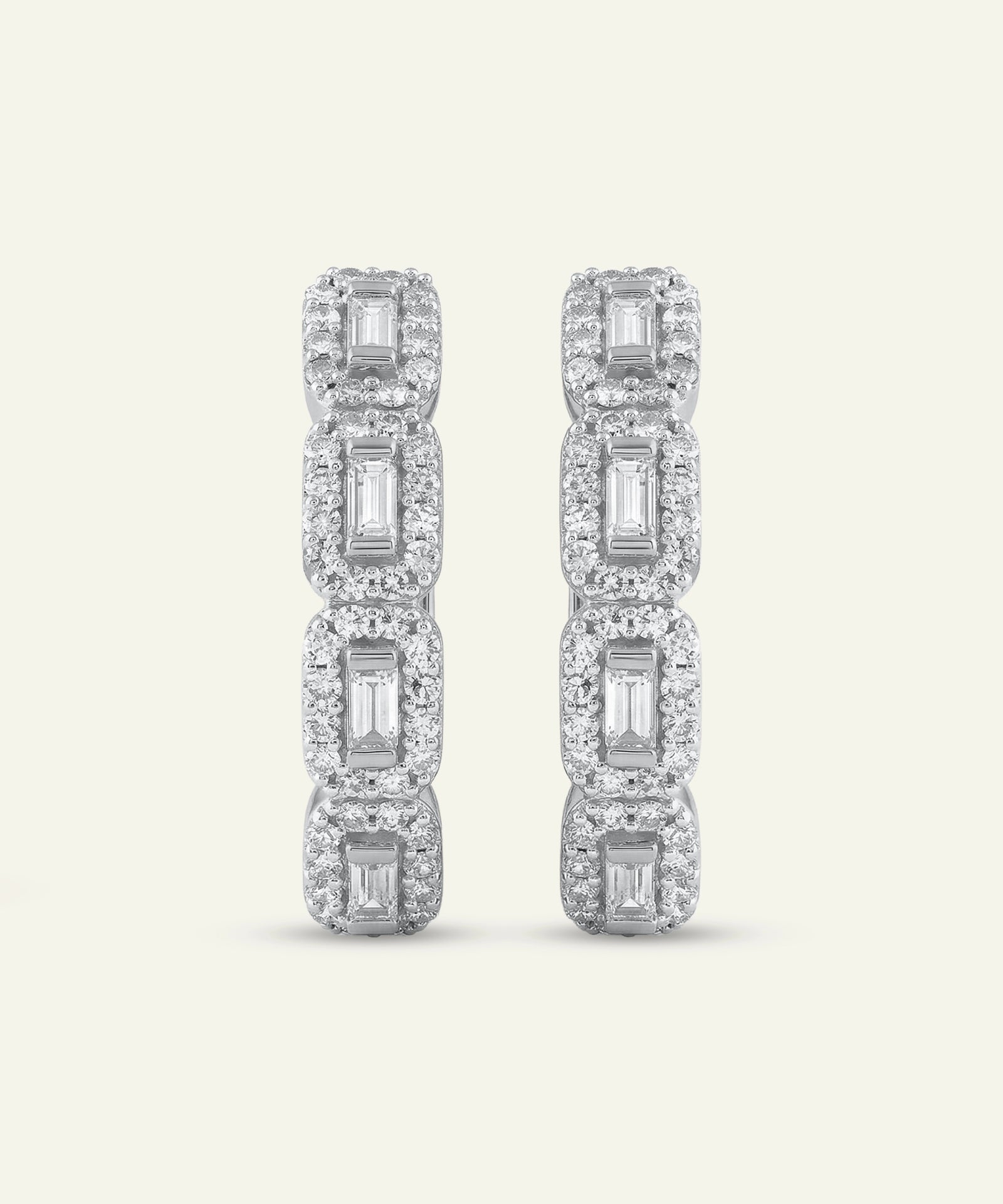 Diamond earrings with rectangular and square cut stones on a light gray background