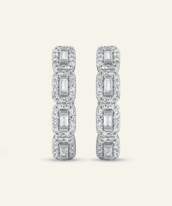 Diamond earrings with rectangular and square cut stones on a light gray background