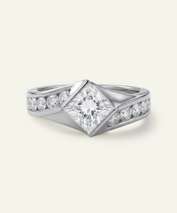 Silver ring with diamond accents on a light gray background
