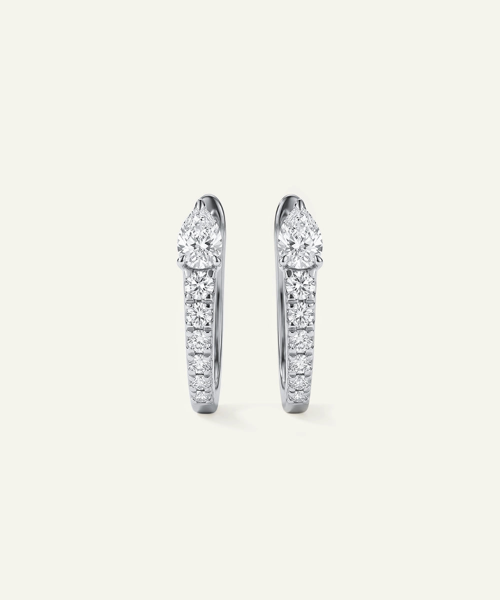 Pair of diamond hoop earrings on a light gray background
