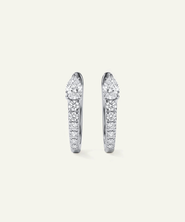 Pair of diamond hoop earrings on a light gray background