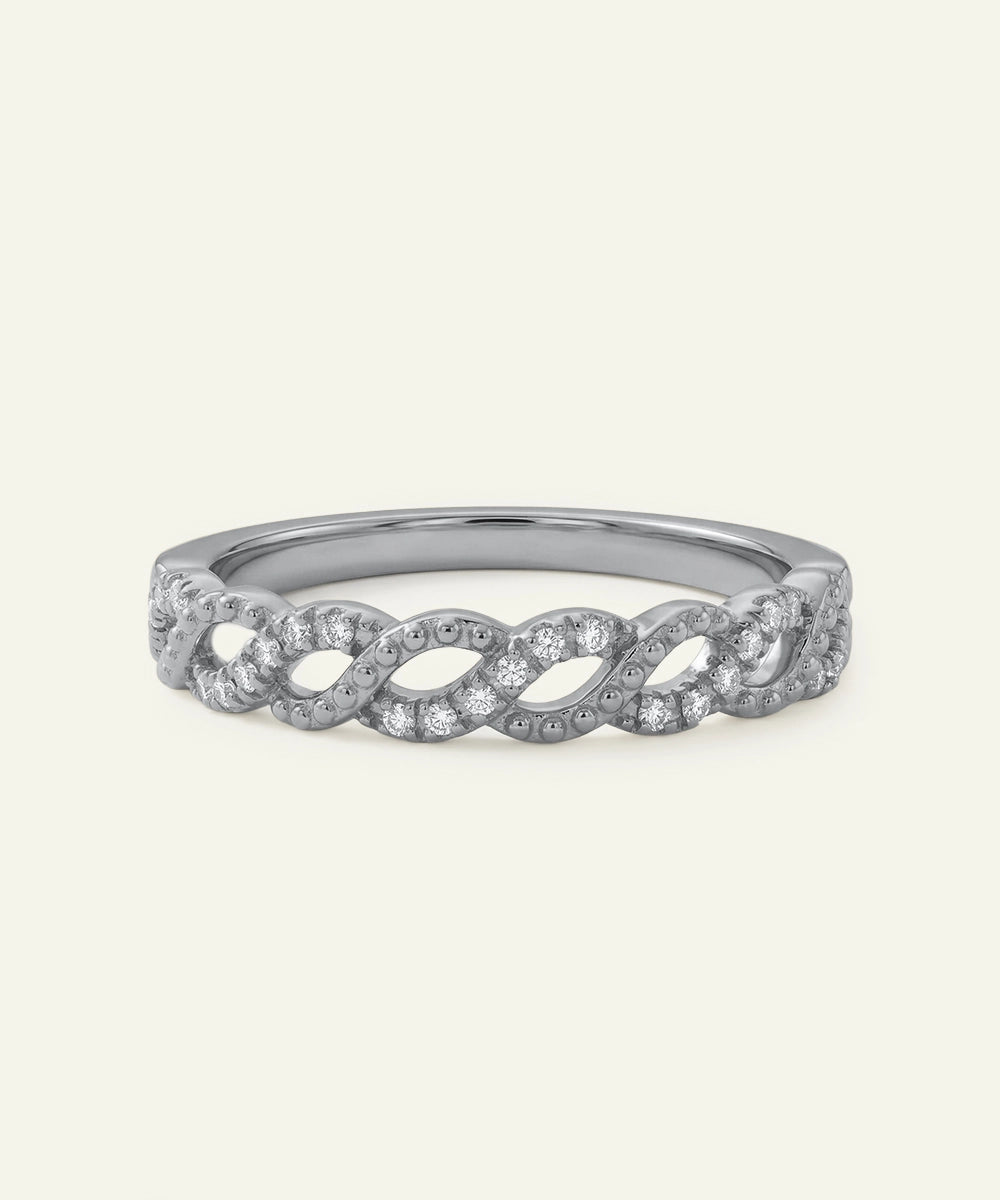 Silver ring with diamond accents on a light gray background