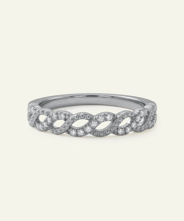 Silver ring with diamond accents on a light gray background