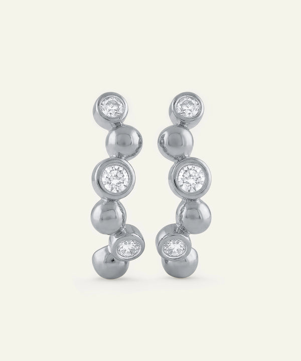 Silver earrings with clear gemstones on a white background
