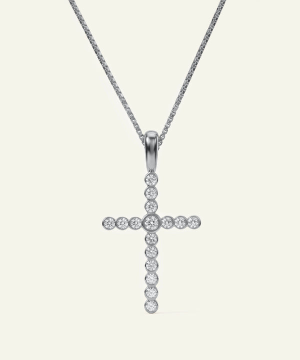 Silver cross pendant necklace on a white background