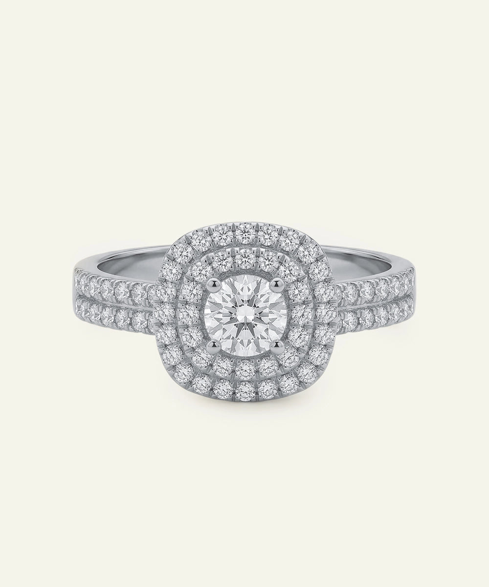 Diamond ring with a double halo on a light gray background