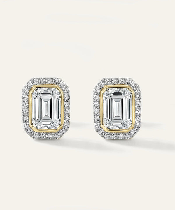 Pair of diamond earrings with gold and silver accents on a light gray background