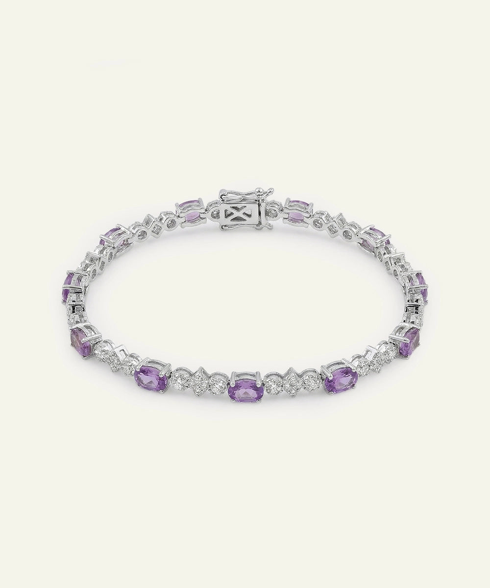 Silver bracelet with purple gemstones on a white background