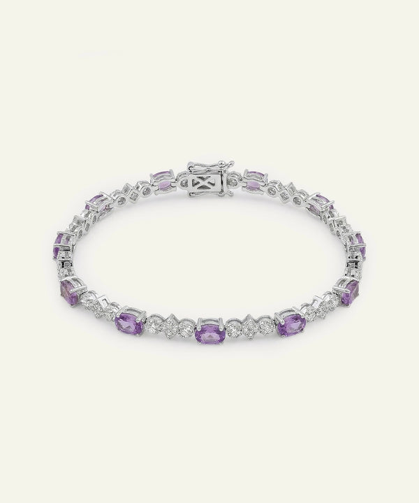Silver bracelet with purple gemstones on a white background