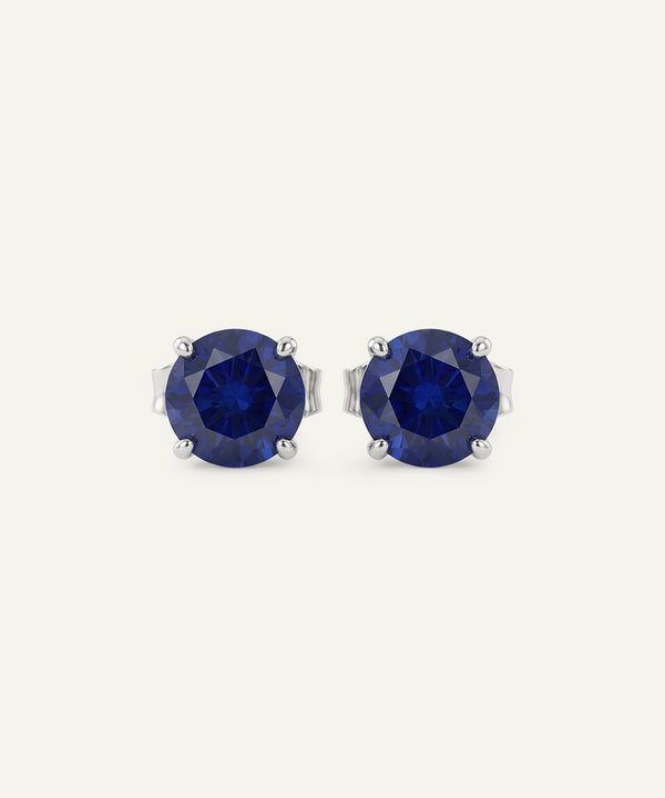 Pair of blue gemstone stud earrings on a white background