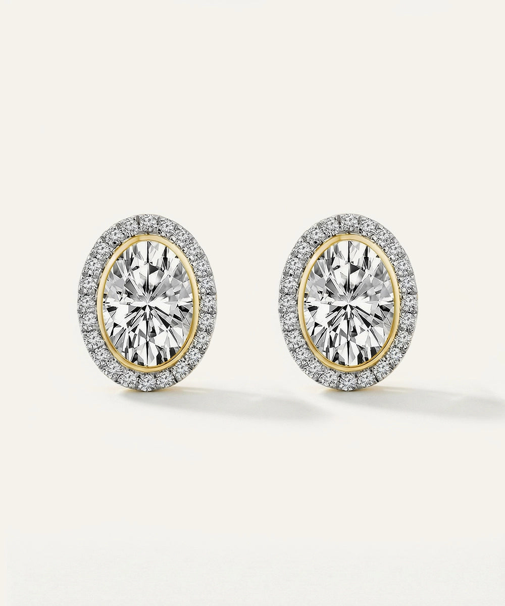 Pair of diamond earrings with gold and silver rims on a white background