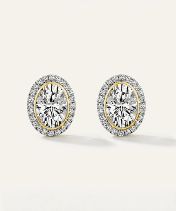 Pair of diamond earrings with gold and silver rims on a white background
