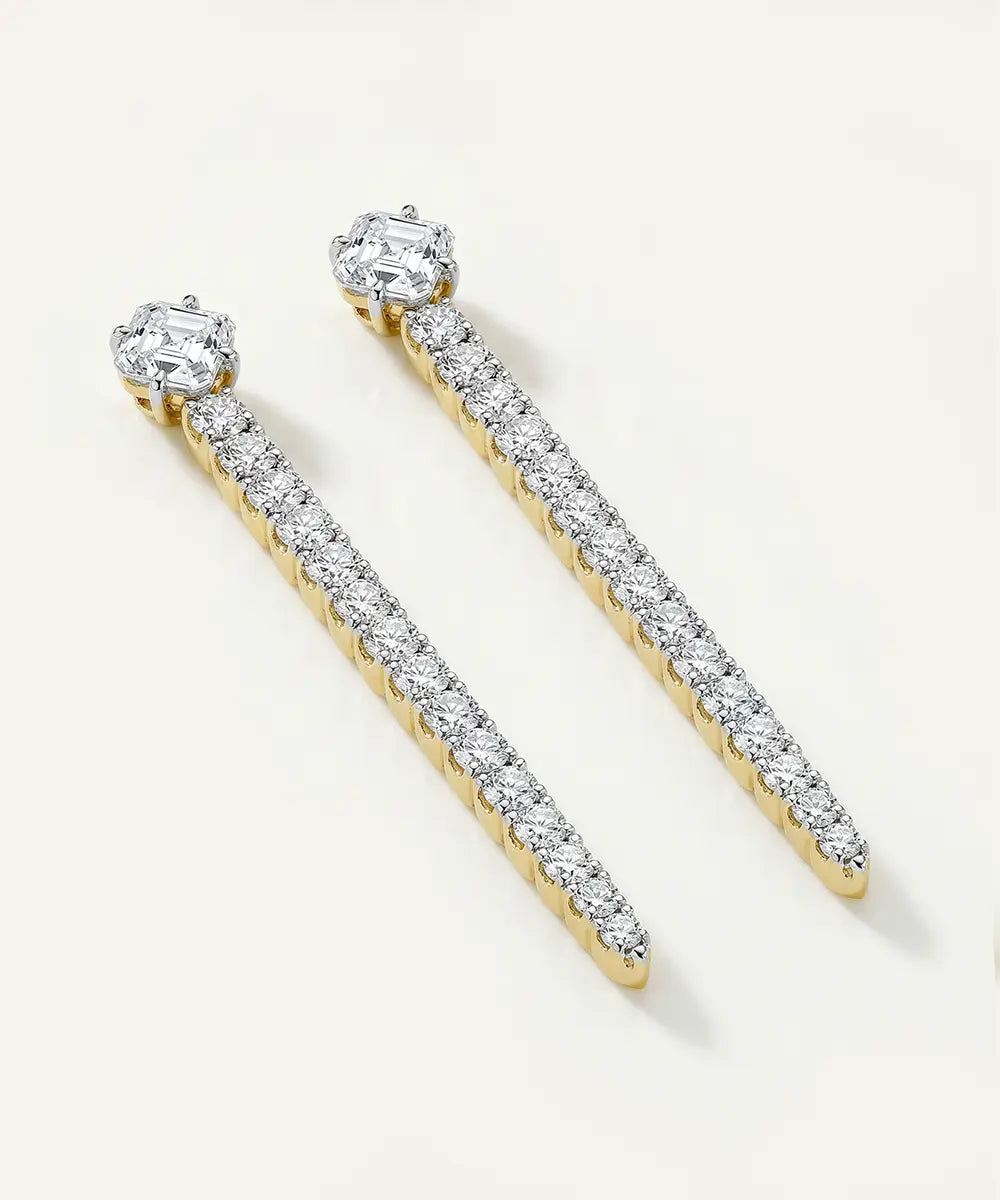 Pair of diamond earrings on a light beige background