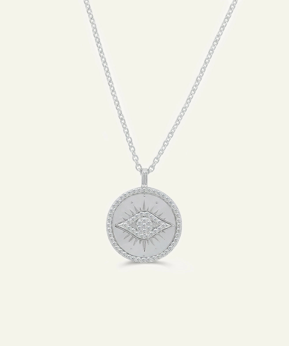 Silver necklace with a round pendant on a light gray background