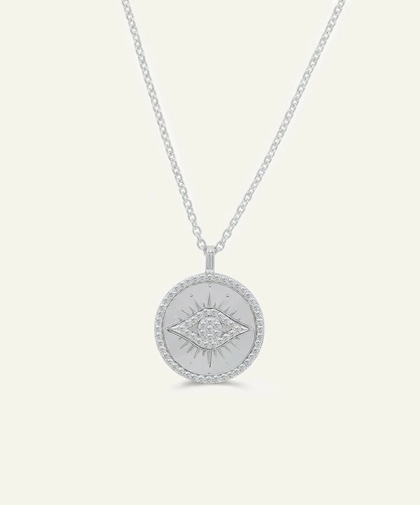 Silver necklace with a round pendant on a light gray background