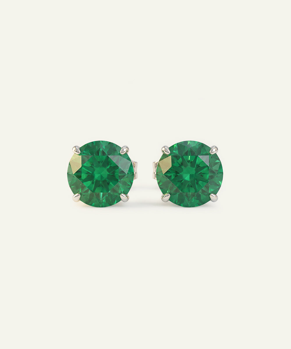 Pair of green gemstone stud earrings on a white background