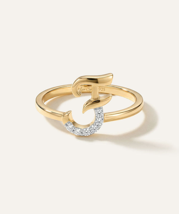 Gold ring with a diamond-studded design on a light background