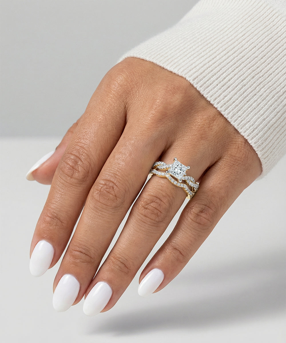 Hand wearing a diamond ring on a neutral background