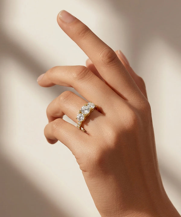 Hand wearing a gold ring with diamonds on a soft beige background