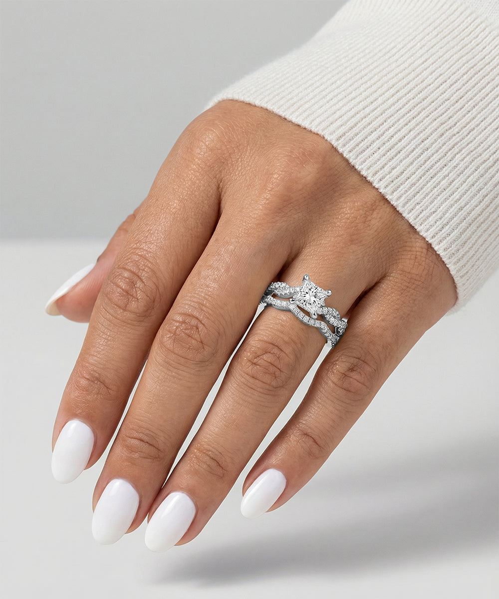 Hand wearing a diamond ring on a neutral background