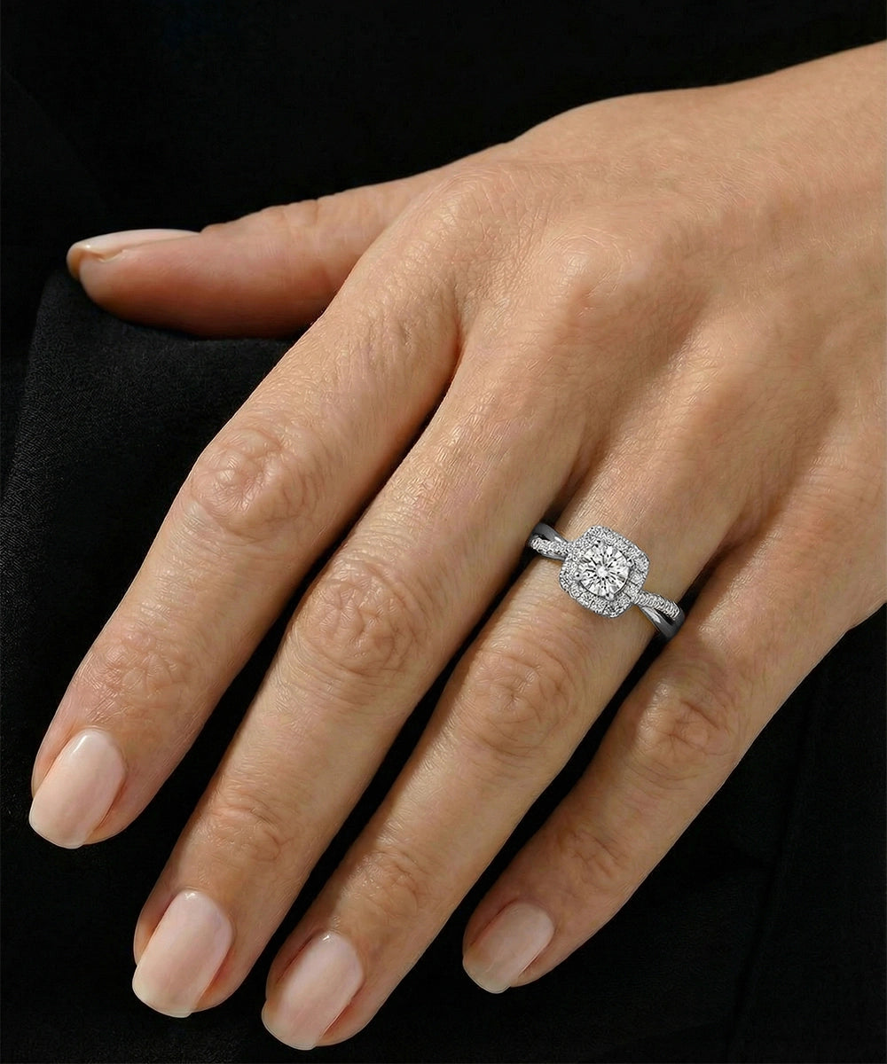 Close-up of a hand wearing a diamond ring on a black background