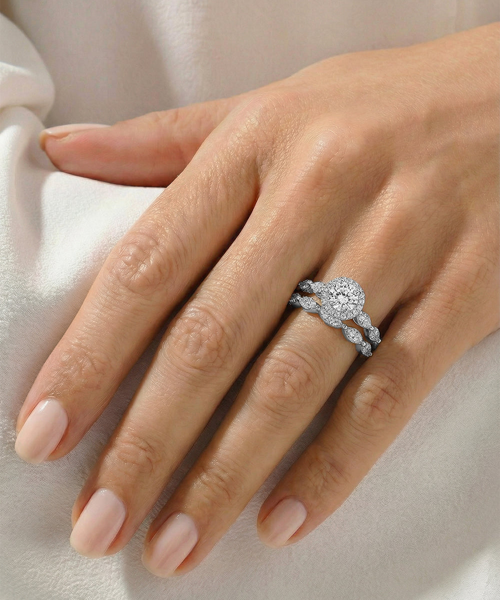 Close-up of a hand wearing a diamond ring on a light background