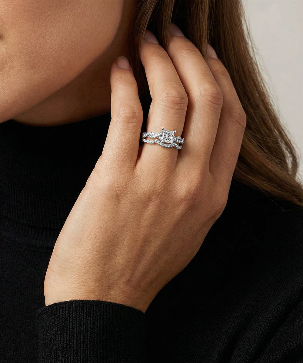 Close-up of a hand wearing a silver ring with a black background