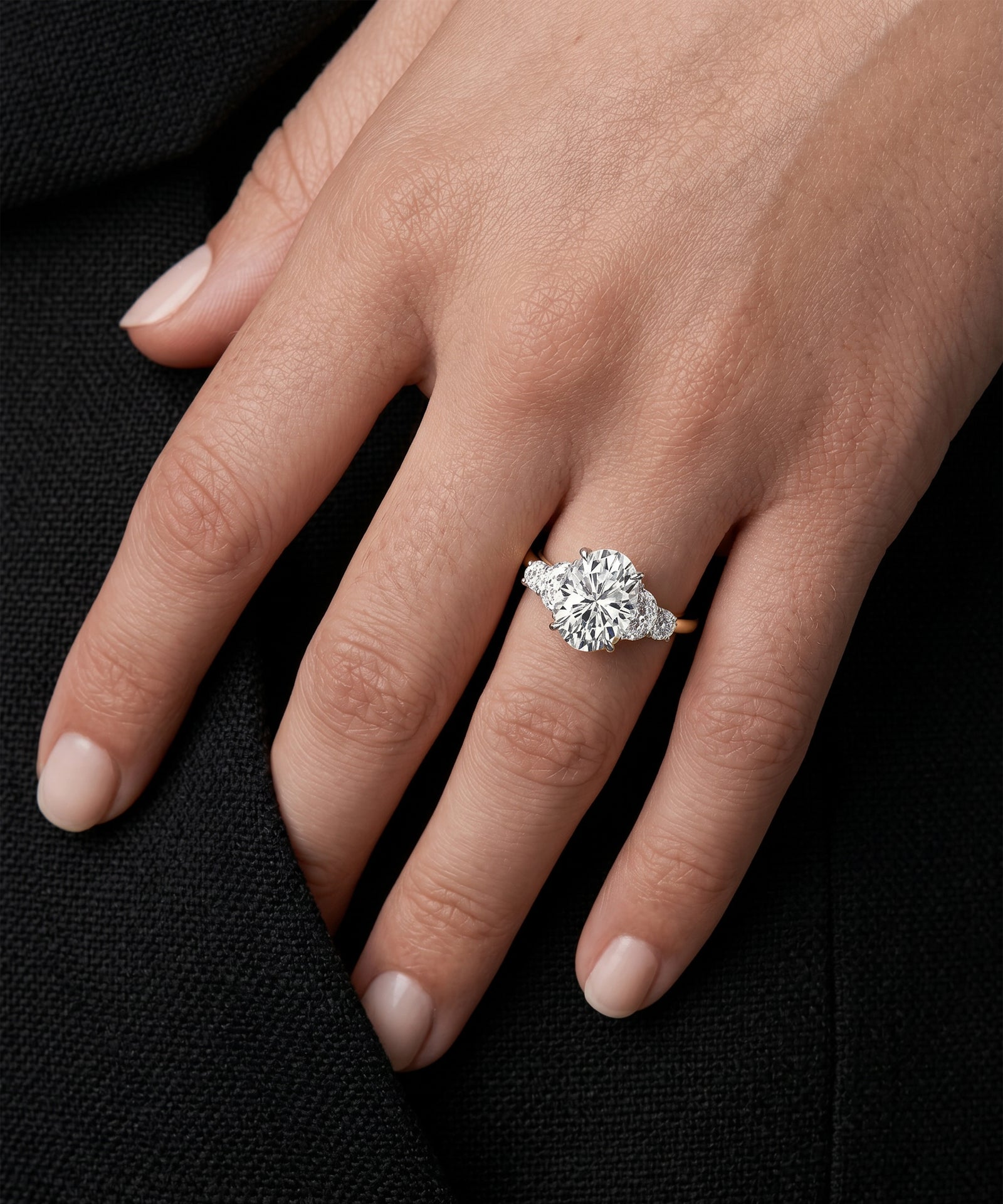 Diamond ring on a hand against a black background
