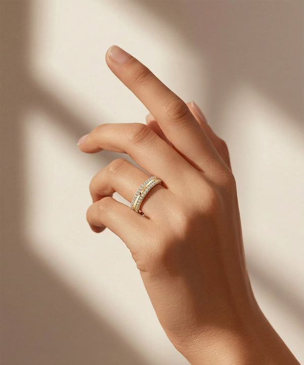 Hand wearing a gold ring on a neutral background
