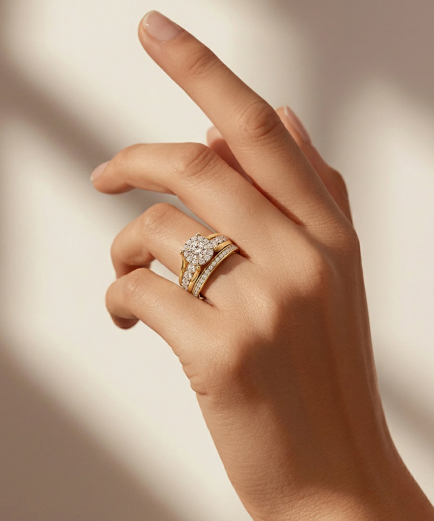 Hand wearing a gold ring with a diamond on a neutral background