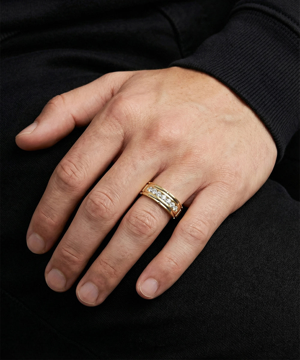 Hand wearing a silver ring with embedded stones on a black background