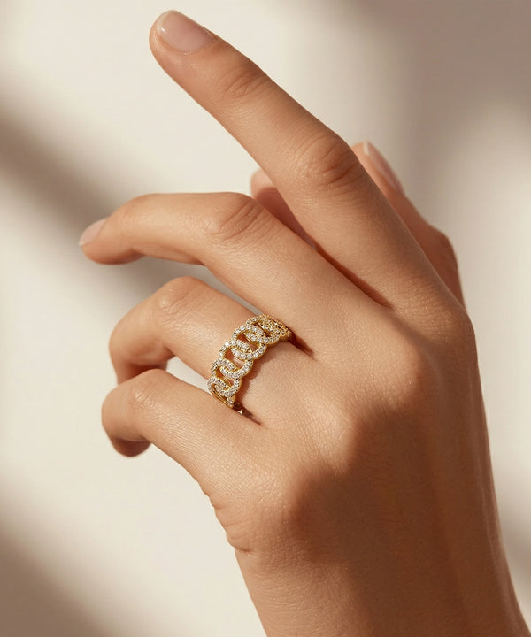 Hand wearing a gold ring with a blurred background