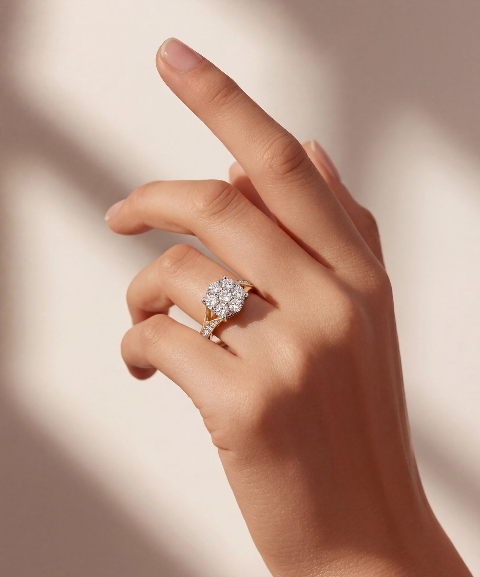 Hand wearing a diamond ring on a soft beige background