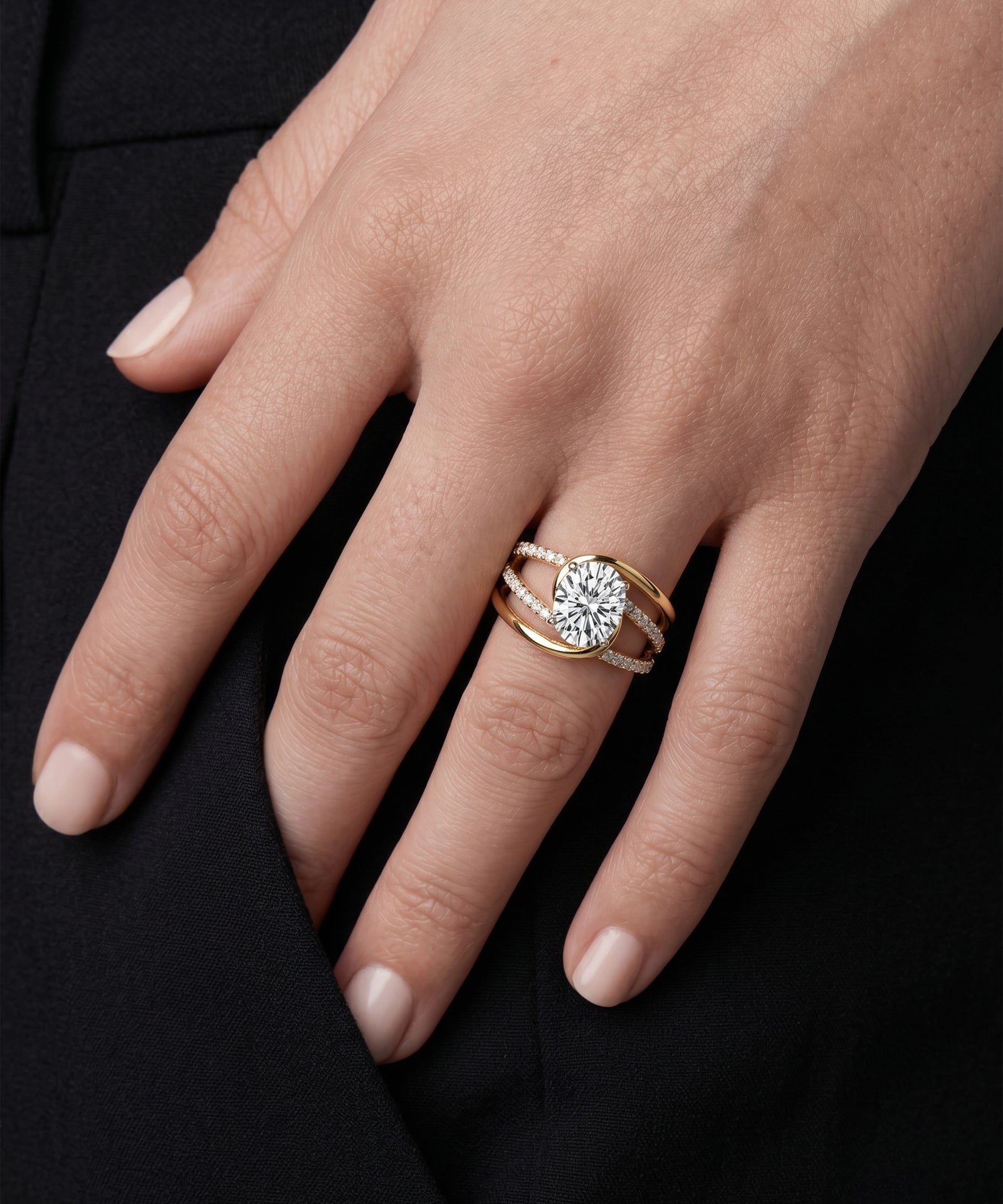 Gold ring with a diamond on a hand against a black background