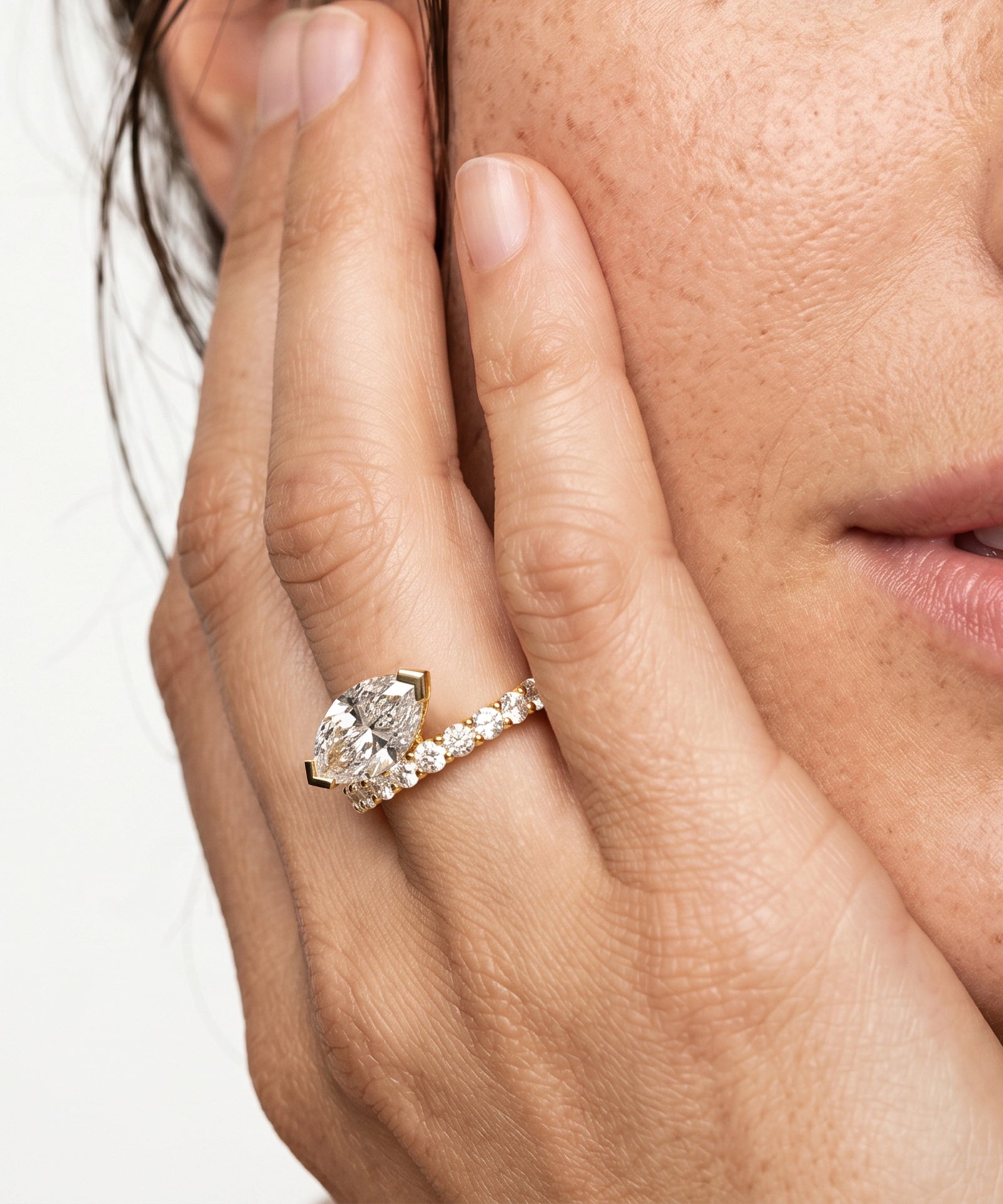 Close-up of a hand wearing a diamond ring with a white background