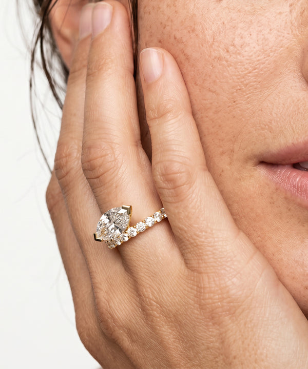 Close-up of a hand wearing a diamond ring with a white background