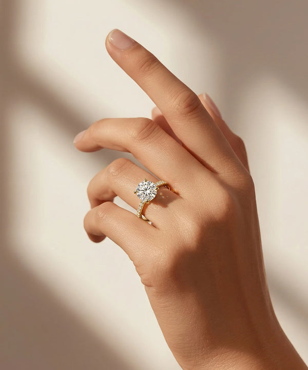 Hand wearing a gold ring with a diamond on a soft background