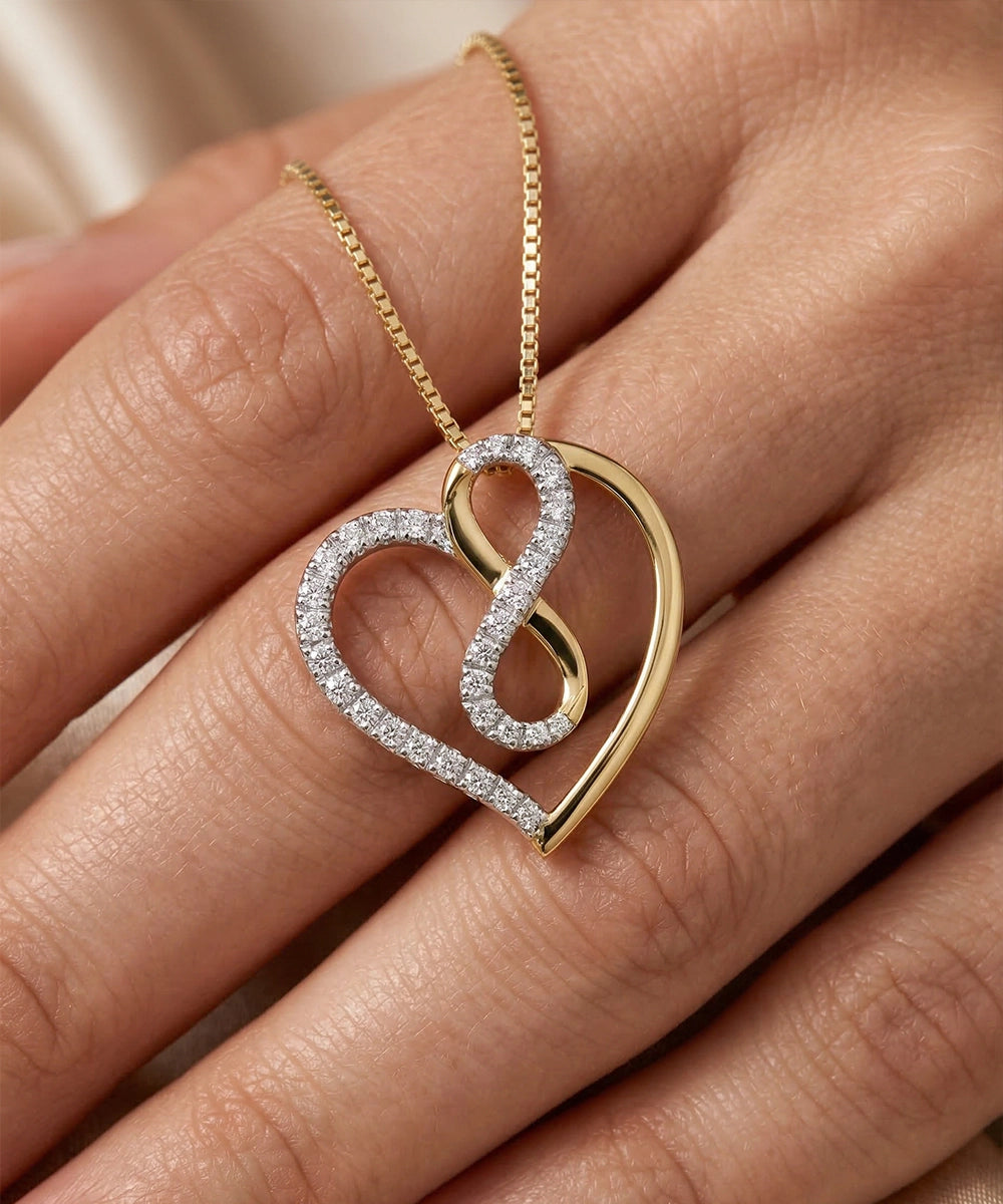 Gold and diamond heart-shaped necklace on a hand