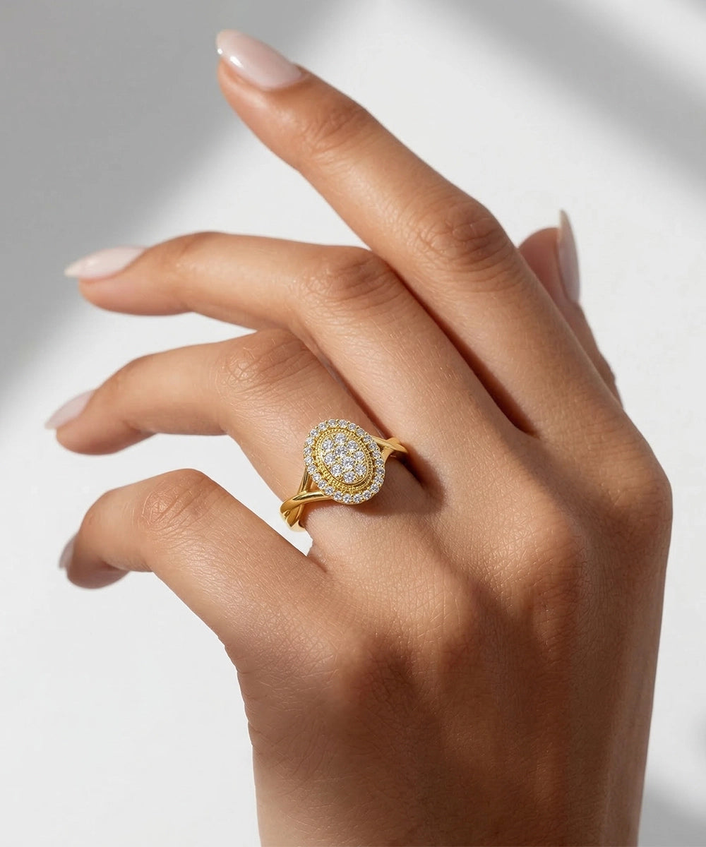 Gold ring with diamonds on a hand against a neutral background
