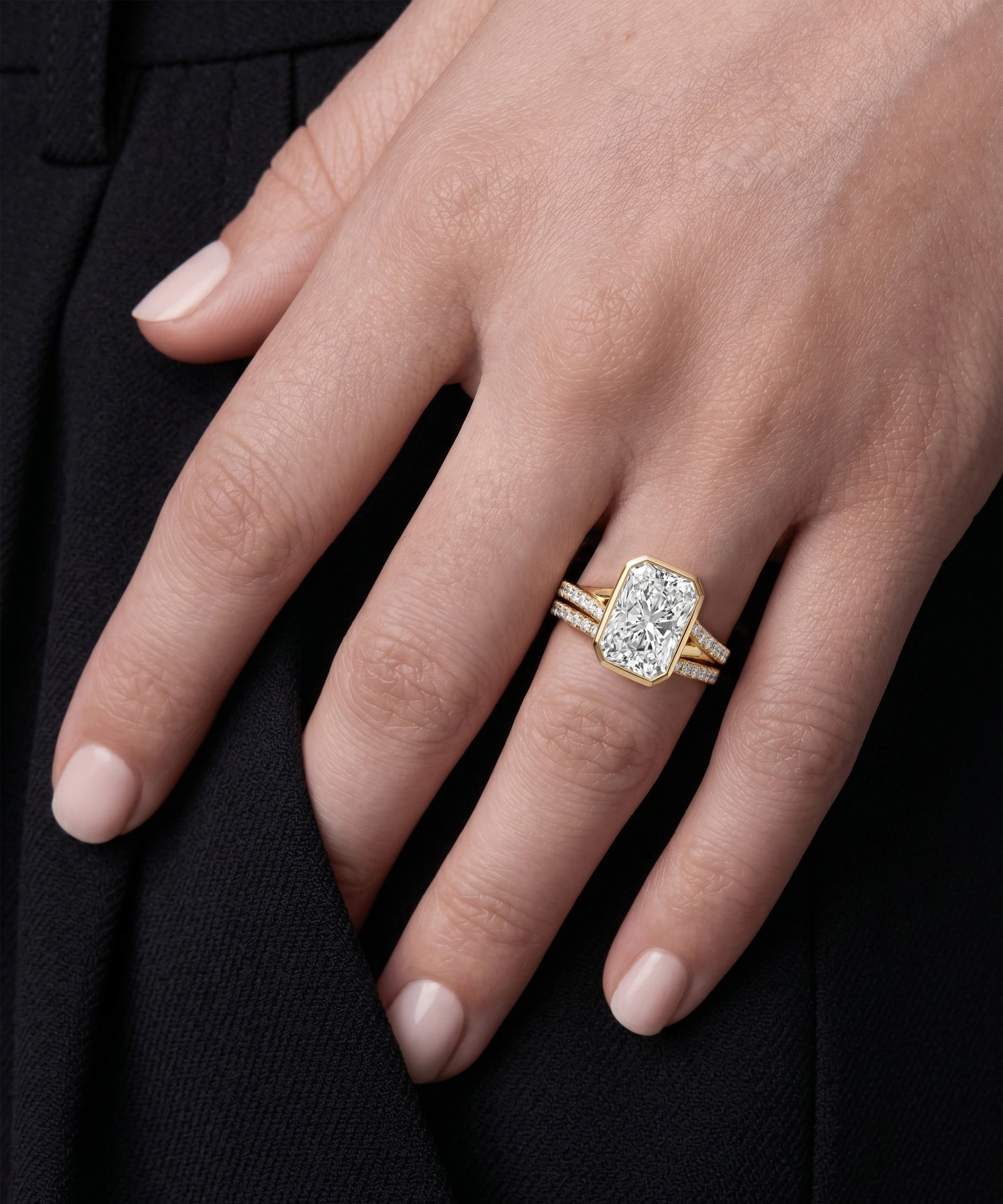 Gold ring with a diamond on a hand against a black background