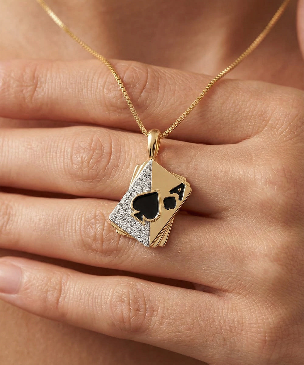 Gold necklace with a diamond-studded card pendant on a hand