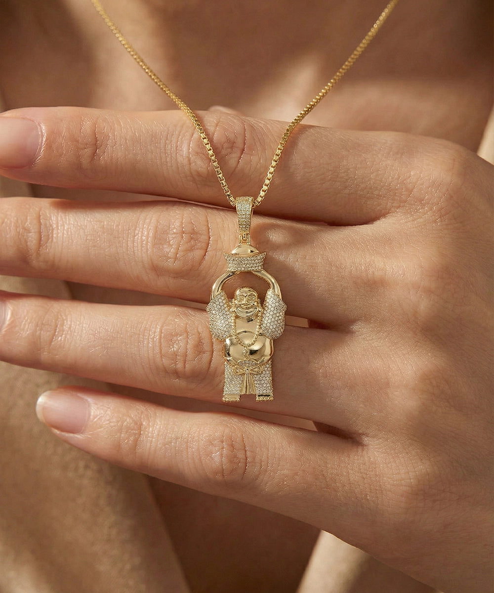 Gold pendant with intricate design held in a hand