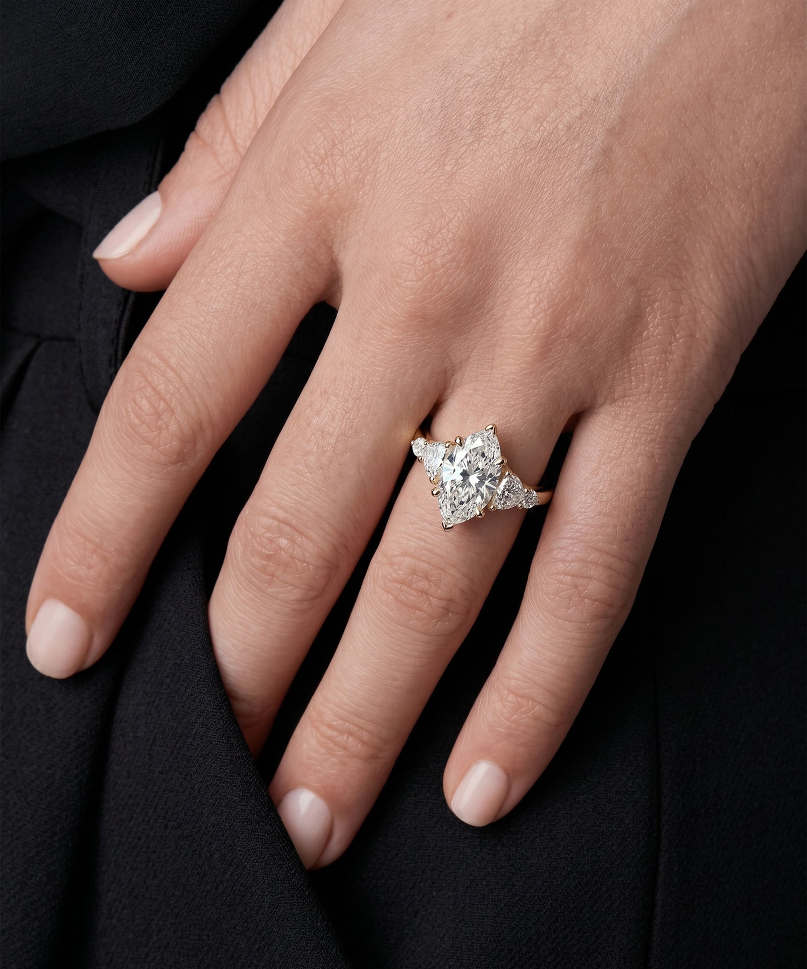 Diamond ring on a hand against a black background