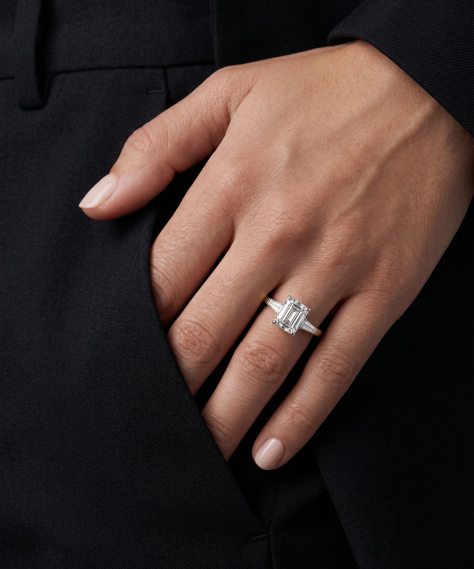 Hand wearing a diamond ring on a black background
